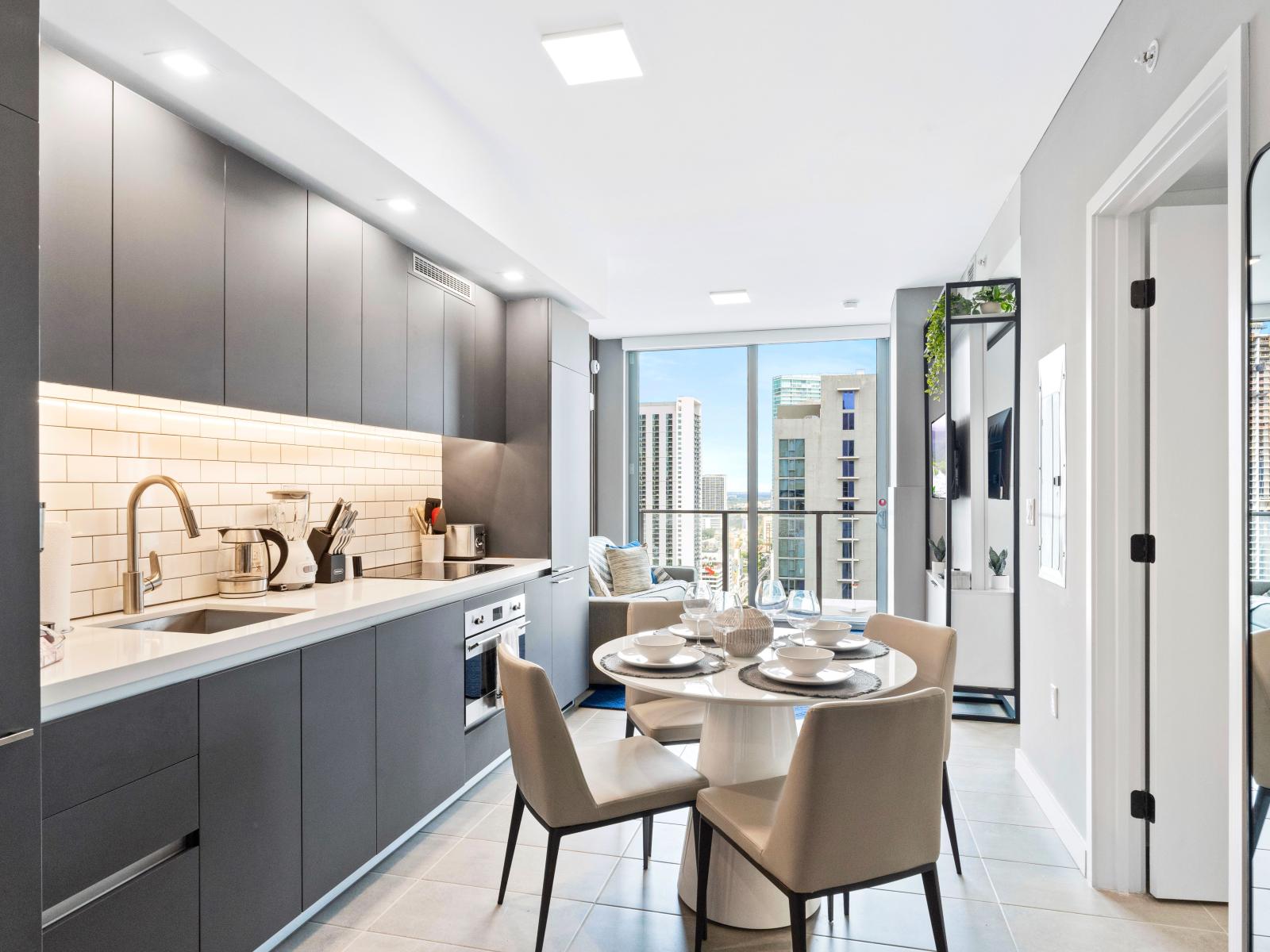 Fully equipped kitchen and dining area - Contemporary fully equipped kitchen with stainless steel appliances, a coffee maker, dishwasher, easy to use amenities and a dining table with seating for four.