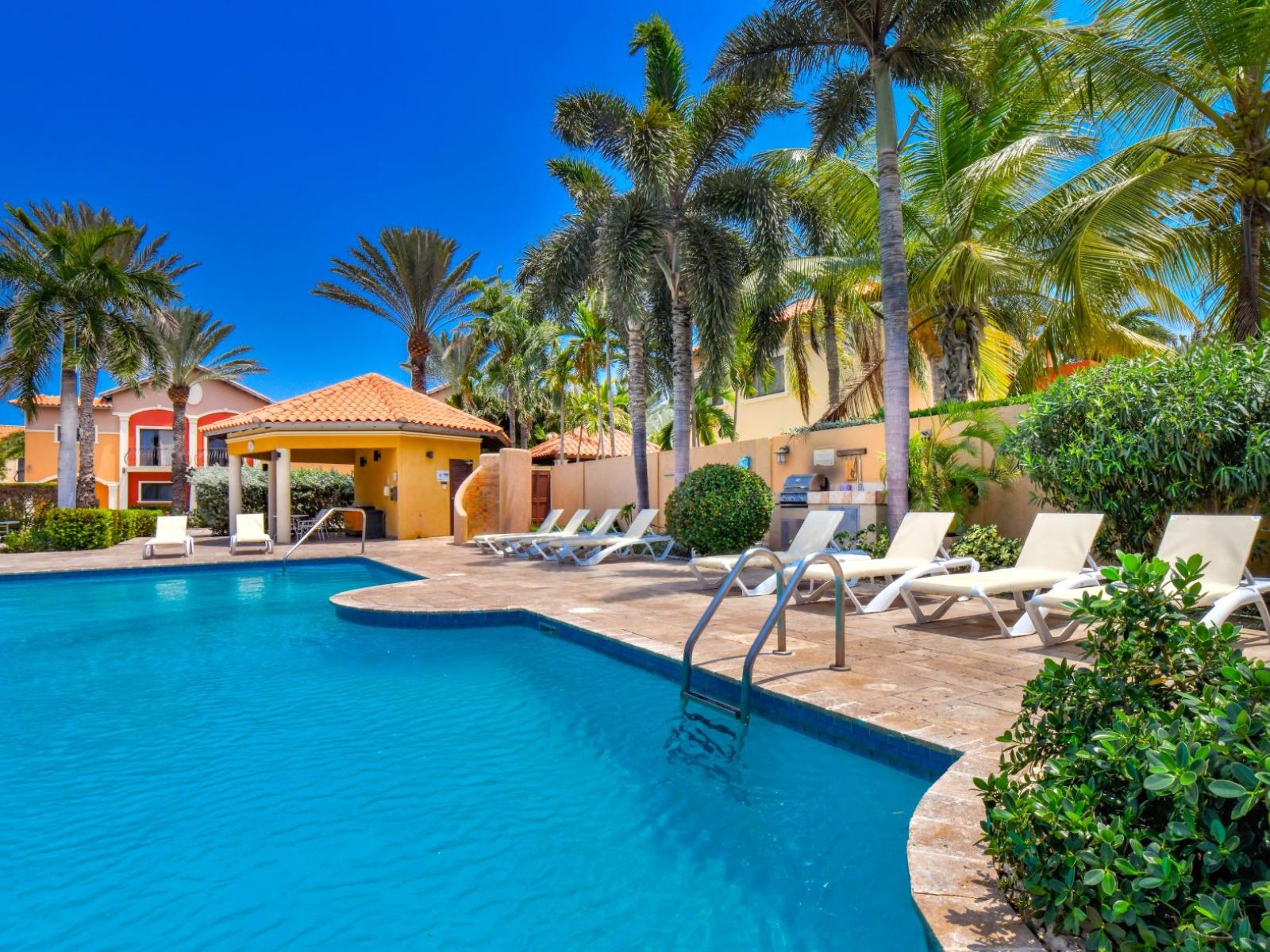 Bask in the sun by the shared pool, complete with comfortable chairs perfect for lounging and soaking up the rays.