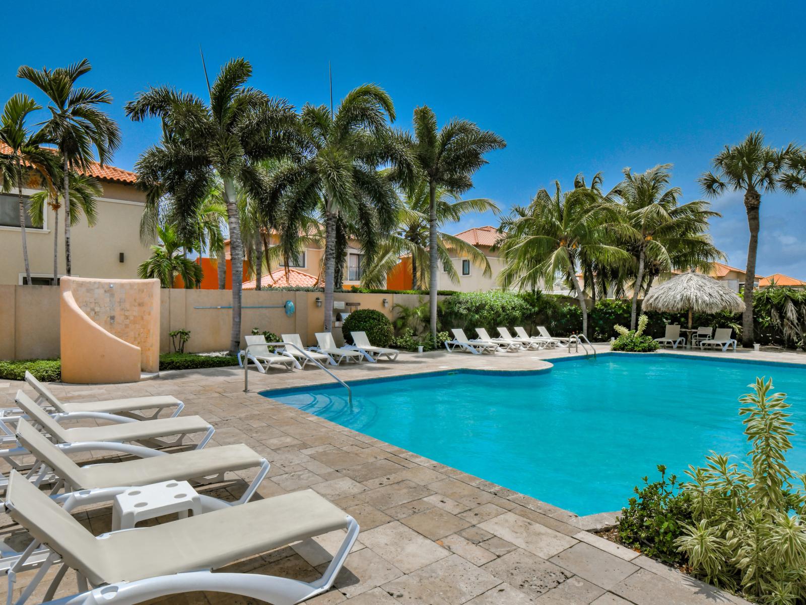 Unwind by the shared pool with numerous pool chairs, ensuring comfort and ample seating for all guests.