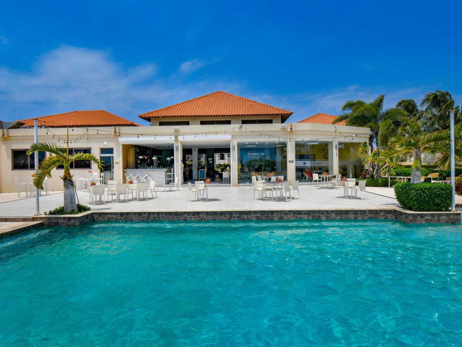 Enjoy the shared pool area with ample shaded seating, designed for relaxation and comfort during your poolside experience