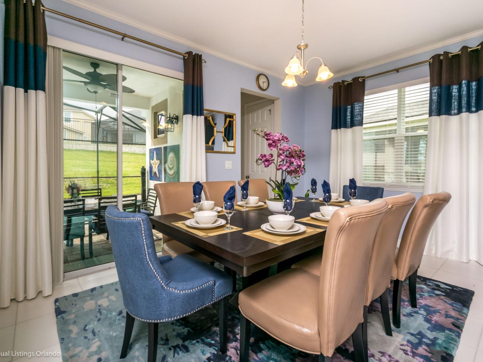 Sleek dining area of the villa in Kissimmee Florida - 8 Persons dining - Artfully arranged table settings for a touch of elegance - Neutral color palette with pops of vibrant hues for a chic contrast - Functional and aesthetically space