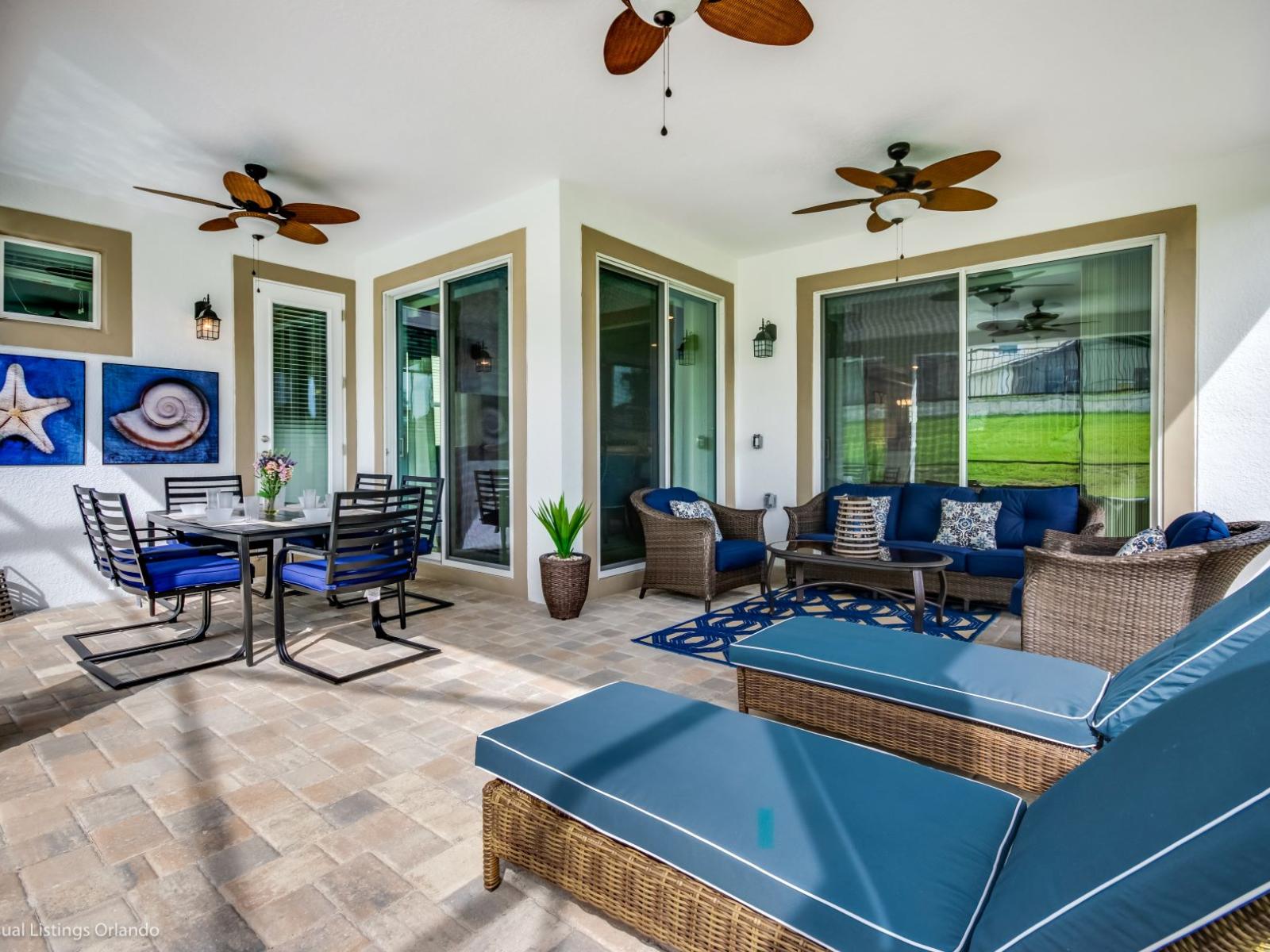 Stunning outdoor area of the villa in Kissimmee Florida - Outside dining table by the pool - Adapt experience for brunch, lunch, or dinner - Lush atmosphere - Cozy seating conductive to relaxation and bonding to create cherished memories