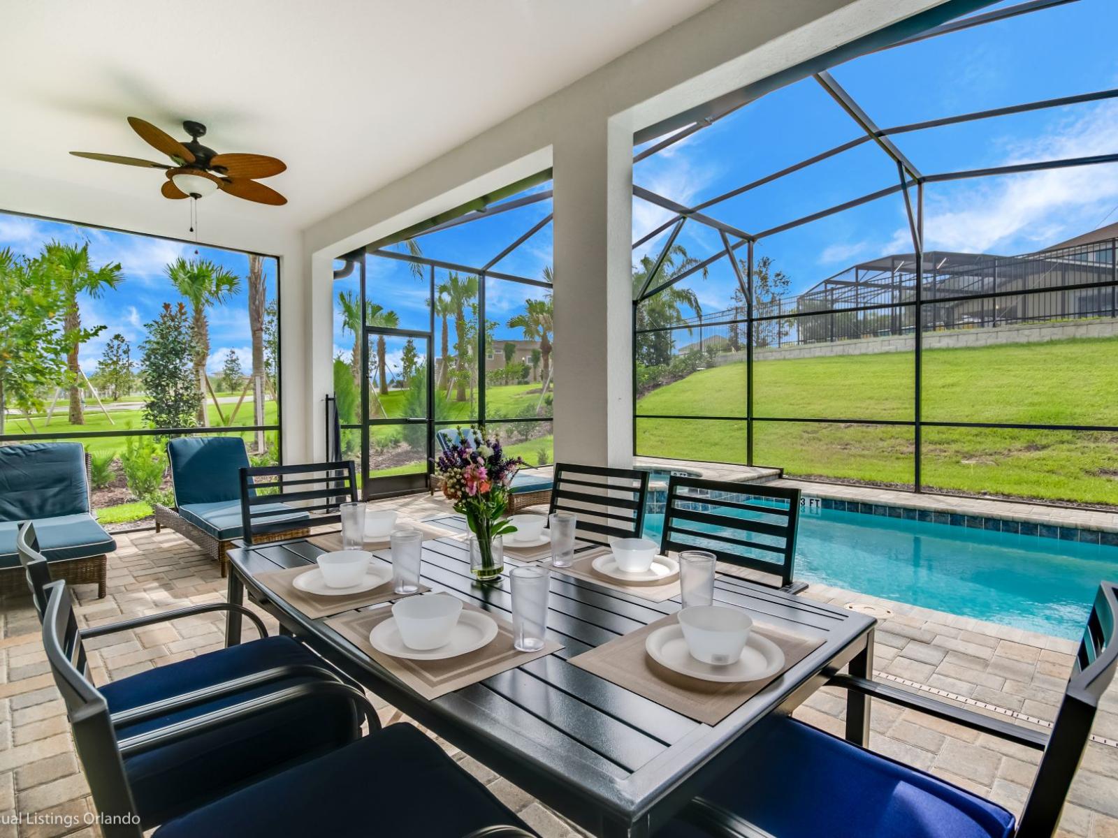 Stunning outdoor area of the villa in Kissimmee Florida - Outside dining table by the pool - Adapt experience for brunch, lunch, or dinner - Lush atmosphere - Cozy seating conductive to relaxation and bonding to create cherished memories