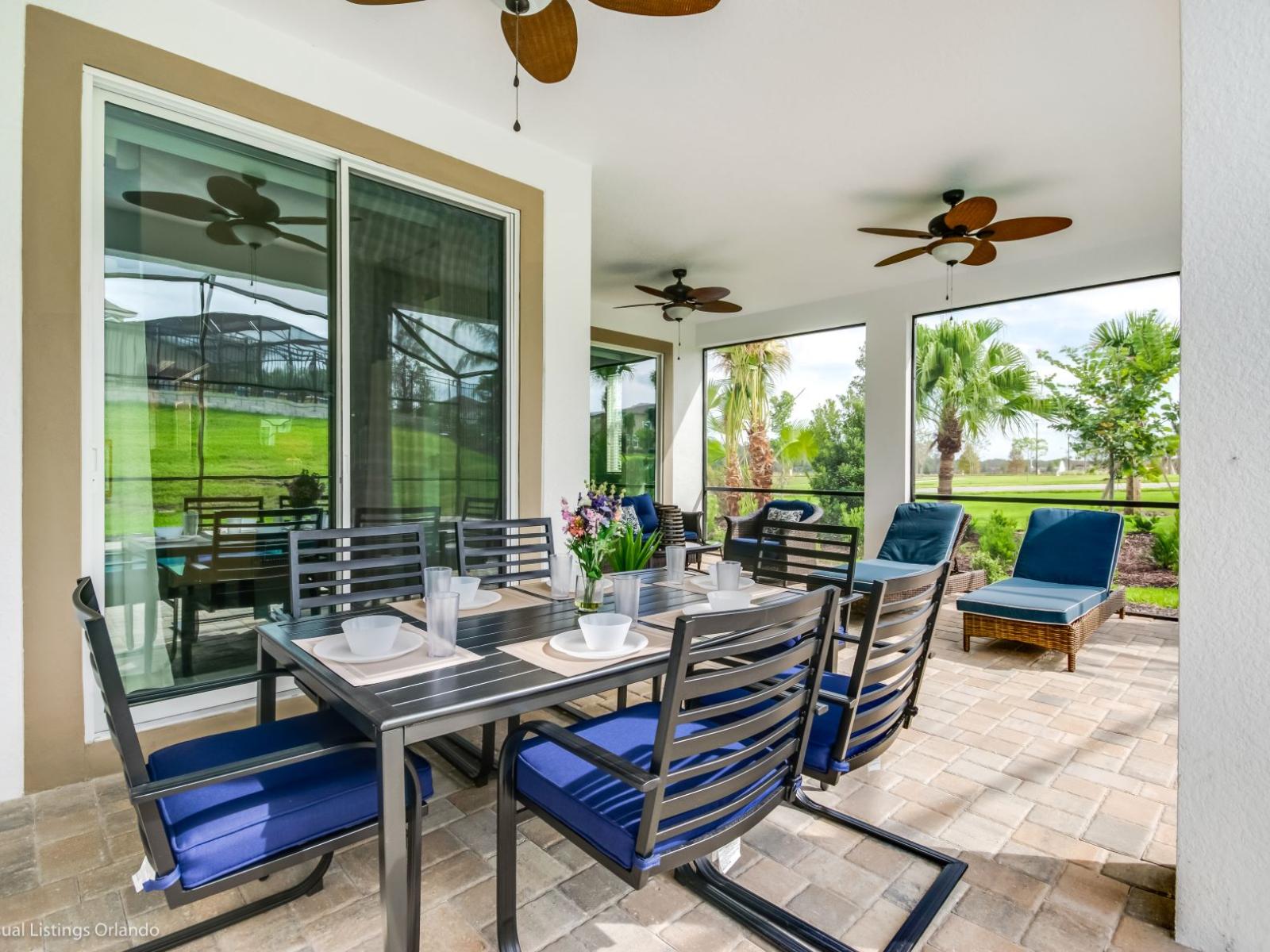 Represent outdoor seating area of the villa in Kissimmee Florida - Extends living space for outdoor enjoyment - Cozy seating area conducive to relaxation and socializing - Comfortable seating beneath the shade, inviting you to unwind