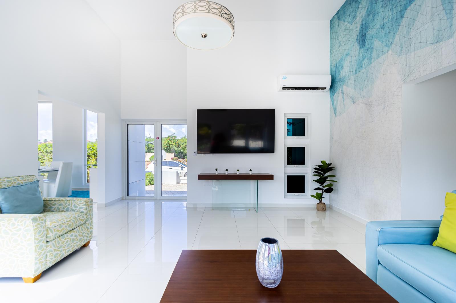 Entertainment Hub: Gather in Our Expansive Living Room, Complete with a Wall-Mounted Flat Screen TV, Offering the Perfect Setting for Movie Nights and Relaxation