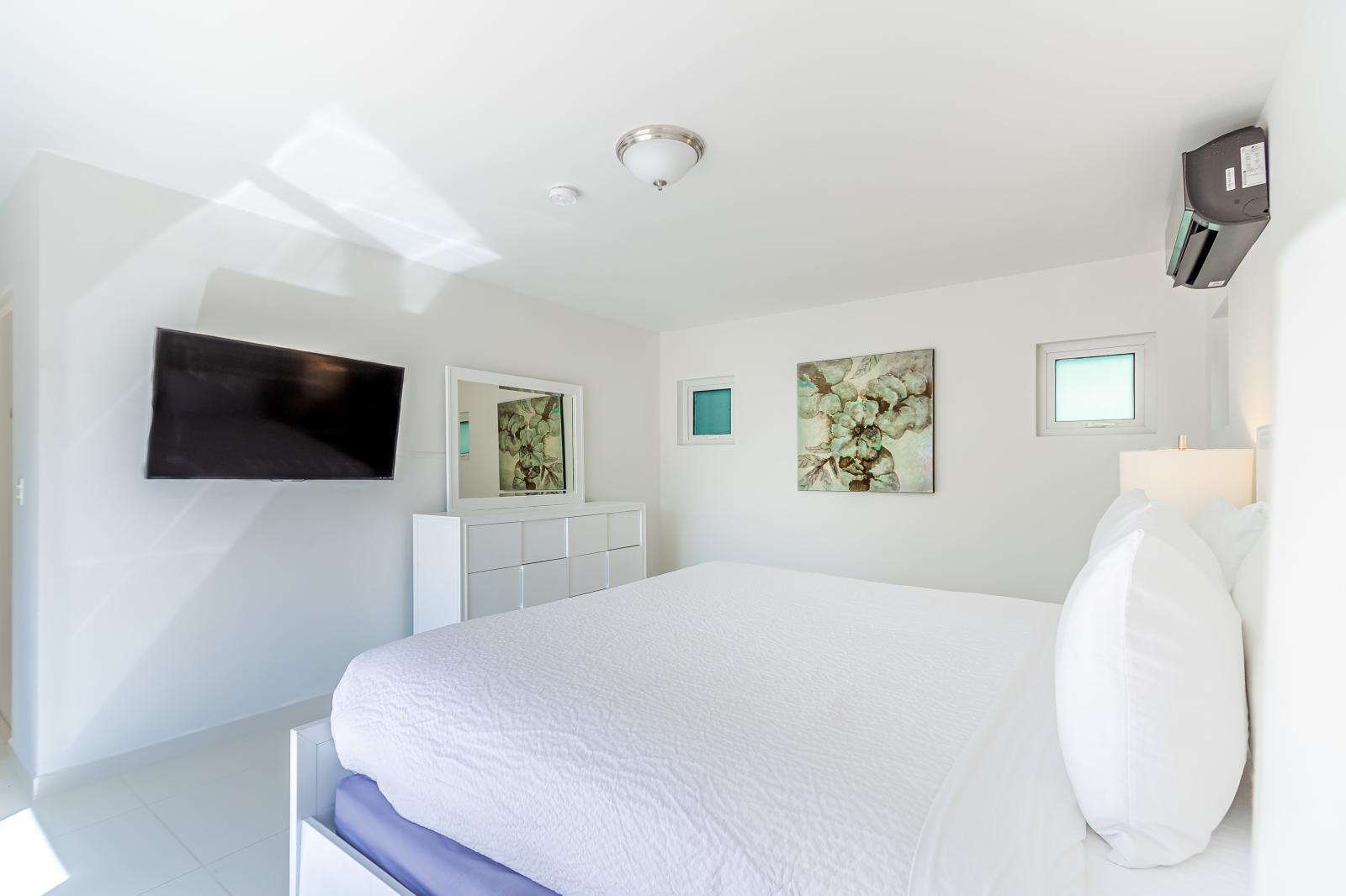 Personal Sanctuary: Bedroom 1 Boasts a Wall-Mounted Flat Screen TV, Providing Private Entertainment and Relaxation for Your Enjoyment
