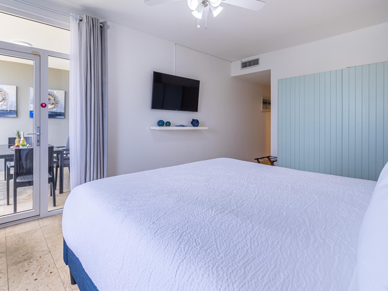 Swish Bedroom of the 2BR Condo in Oranjestad Aruba - Smart TV and Netflix - Access to Balcony with lush views - Luxurious bedding for a restful night's sleep - Attached Bathroom