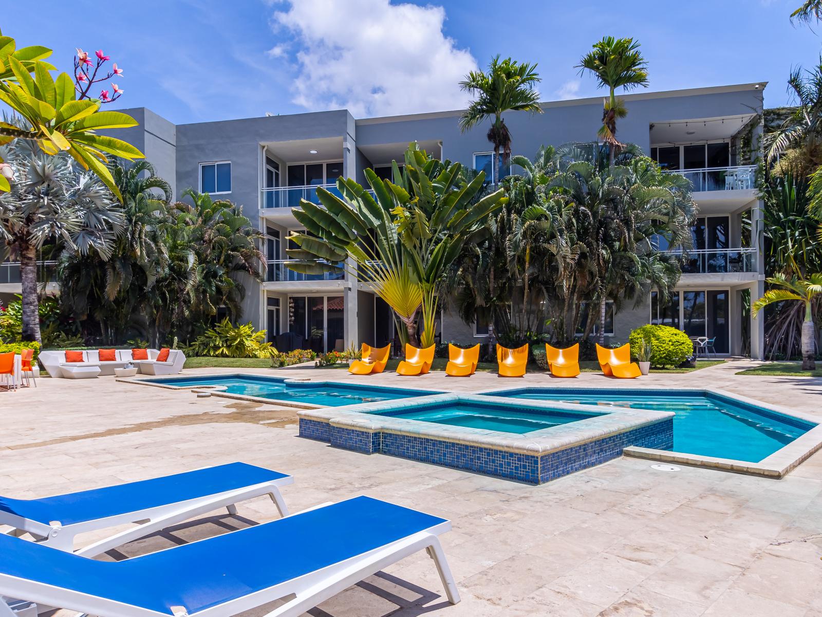 Shared pool with lots of chairs to lounge in the sun