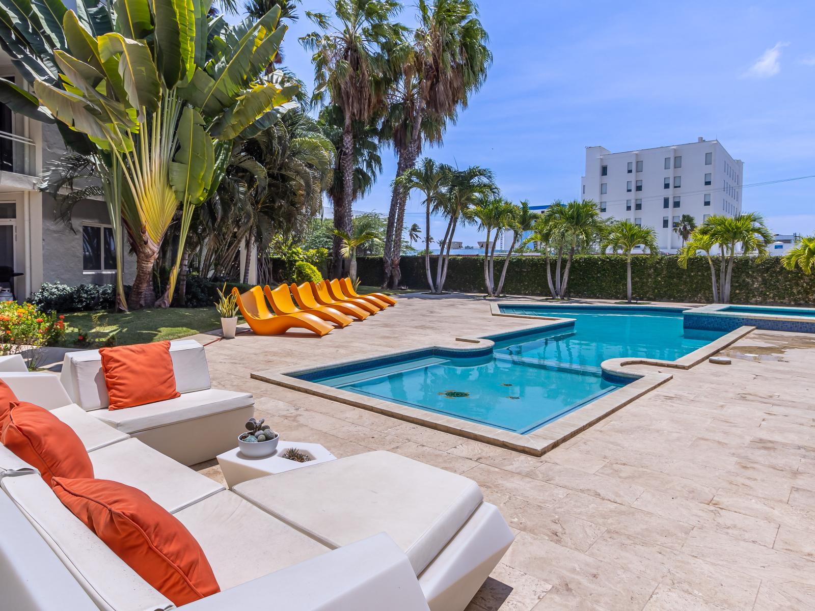 Shared pool with lots of chairs to lounge in the sun