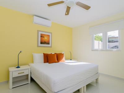 Captivating Bedroom of the 4BR Home in Noord Aruba - Modern bedroom with sleek design and ample natural light - Minimalist decor, creating a clean and uncluttered sleeping space - Seamless blend of comfort, aesthetics, and functionality