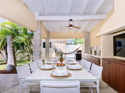 Elite outdoor dinning of the Villa in Noord, Aruba - 8 Persons beautiful dinning - Availability of TV and Netflix - Lush and vibrant atmosphere - Lawn facing dinning area - BBQ grill available - Ample amount of storage