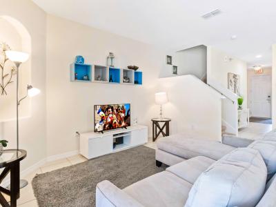 Welcoming Living area of the townhouse in Davenport Florida - Elegantly decorated space with a neutral color palette for a timeless appeal - Well-chosen lighting fixtures adding both functionality and charm - Comfy sofas and Smart TV