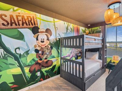 Mikey Themed Bedroom of the Townhouse in Davenport Florida - Featuring 3 single size beds and 1 double size bed - Bedroom with a cozy ambiance, blending comfort and aesthetics - Micky mouse safari retreat