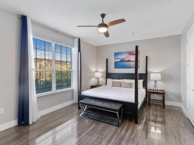 Panoramic main bedroom of the condo in Orlando - Featuring a lavish king-size bed - Serene sanctuary where relaxation reigns supreme. - Decored with Island view wall painting