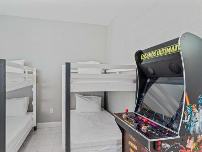 Discover endless fun in Bedroom 3, equipped with two single size bunk beds and an arcade game, creating a playful retreat for kids and adults alike.