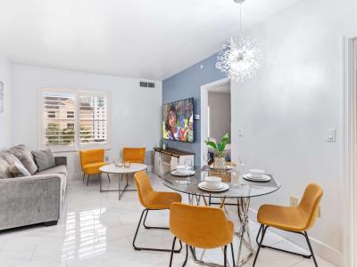 Living room with large smart TV, sleeper sofa and kitchen