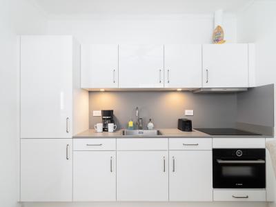 Elegant Kitchen of the Apartment in Noord Aruba - Integrated appliances for a seamless and stylish appearance - Innovative storage solutions to maximize space efficiency