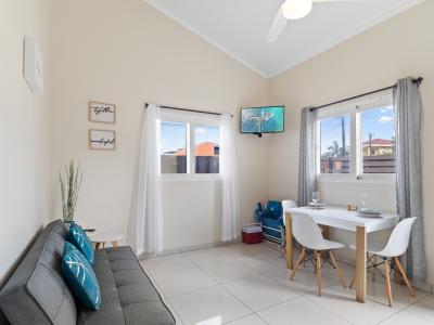 Lavish living and dinning area of the apartment in Noord, Aruba - Cosy sofas - Beautifully located windows of the apartment with outside views - 3 Persons dinning - Beautifully decored with wall paintings - Availability of TV and Netflix