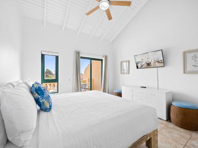 Bright bedroom of the condo in Noord Aruba - Features a king size bed for restful nights - Balcony access with seating for outdoor moments - Smart TV for endless entertainment