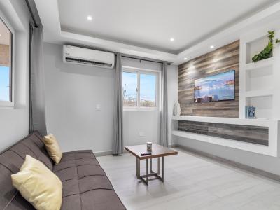 Charming living area of the apartment in Oranjestad Aruba - Smart TV for entertainment - Stylish furniture arrangement providing comfort and a cohesive look - Comfy sofa for relaxation