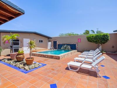 Dive into relaxation in pristine private pool of the home in Noord Aruba - Harmoniously integrated into the lush natural surroundings - Inviting poolside loungers for basking in the sunshine and BBQ for added convenience