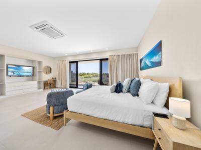 Indulge in a blissful retreat in deluxe bedroom of the apartment in Noord Aruba - Offering king size bed, smart TV and a private balcony for an unforgettable stay - This spacious bedroom comes with comfortable seating for added convenience