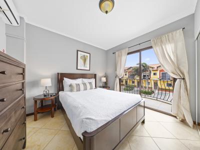 - Enjoy a peaceful retreat in the cozy bedroom of the townhouse in Noord, Aruba. - The bedroom features direct access to a balcony. - This bedroom offers a cozy bed and tasteful decor. - Wake up to beautiful views and fresh breezes from the balcony.