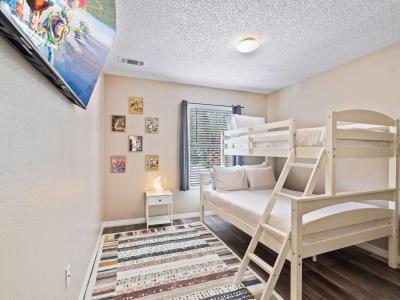 This charming bedroom is perfect for kids , featuring sturdy bunk bed with a twin over full configuration - Decorated with playful artwork and includes a flat-screen TV, providing entertainment - Designed to ensure a comfortable and enjoyable stay