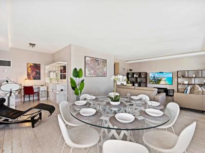 - Open living and dining area with modern furnishings, perfect for enjoying meals - Elegant glass dining table set for eight, ideal for family dinners or gatherings  -Spacious layout with comfortable seating enhancing overall experience of relaxation