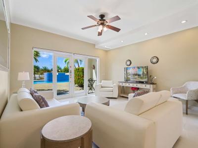 Relax in this bright and inviting living area, featuring cozy seating, a smart TV, and direct access to a serene private pool and lush tropical views – the perfect retreat for your next vacation.