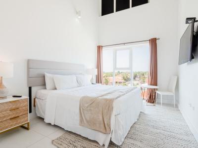 Bedroom 1 features a queen size bed and luxe heigh ceilings