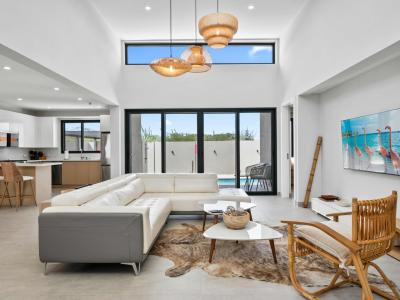 Beautifully designed living space with high ceilings & plenty of natural light - Open layout connects seamlessly to the kitchen & private pool - Kick back on the comfy sectional, stream your favorite shows, and soak up the vacation vibes