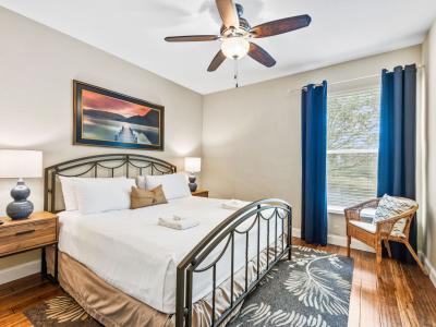 Primary Bedroom with king-size bed, smart-TV, ceiling fan and walk-in closet