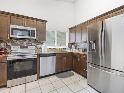 ully equipped kitchen featuring stainless steel appliances, granite countertops, modern tile backsplash, and all the essentials for preparing meals during your stay.