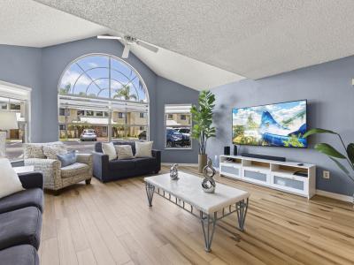 📺 Bright & Relaxing Lounge Space – Enjoy movie nights on the smart TV in this sun-filled living room with vaulted ceilings and large arched windows that bring the outdoors in. #SmartTV #NaturalLight #FamilyTime