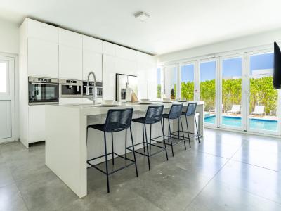 Chic Kitchen of the Villa in Noord Aruba - Fully Equipped - Breakfast Bar with bar chairs - Functional layout designed for efficient meal preparation - Amazing pool views