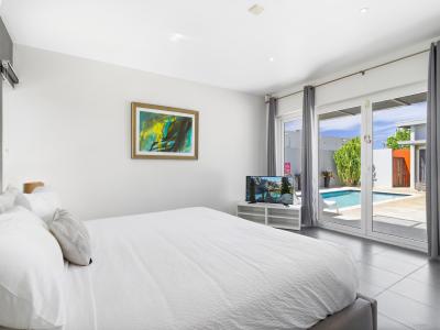 Experience luxury in Main Bedroom 1 with its king-size bed and scenic pool view.