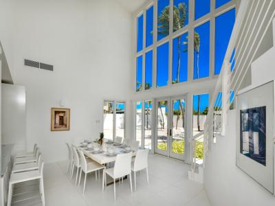 Ritardando Dining Area of the Villa in Noord Aruba - High ceilings creating sense of spaciousness - 8 Persons Dining - Floor-to-ceiling windows flood the space with natural light, offering stunning views