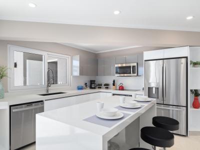 Modern Kitchen of the villa in Noord Aruba - Meal Bar and Bar chairs - Elegant and coordinated color palette for a cohesive look - Fully Equipped - Open concept connecting the kitchen to the dining