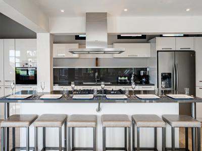 Modern kitchen of the Villa in Noord Aruba - Integrated appliances for a seamless and stylish appearance - Open concept connecting the kitchen to the dining and living area - Functional island for additional workspace