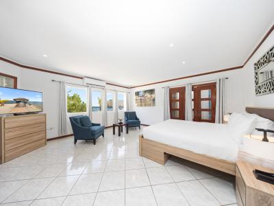 Experience unparalleled comfort in the phenomenal main bedroom. Sink into the king-size bed, where dreams are indulged amidst plush linens. Wake up to spectacular views through the bedside window, offering a glimpse of Aruba's nature