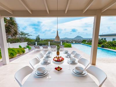 Wonderful dinning area of the Home in Santa Cruz, Aruba - 8 Persons Beautiful Dinning - Private terrace dinning space beside the glorious pool - Elegant Chandelier - Refreshing environment - Cosy beach chairs to relax - Soul enhancing space