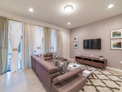 Open-concept living area of the townhouse in Kissimmee, Florida -  Comfortable seating in the living area that convey a sense of relaxation -  Presence of natural light can enhance the overall ambiance - Smart tv with Netflix