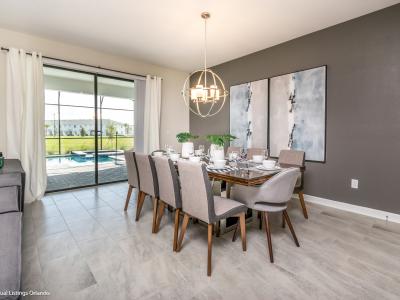 Sleek dining area of the home in Kissimmee Florida - Sophisticated design with a blend of modern and classic elements - 10 persons dining with elegant lighting - Harmonious color scheme for a cohesive and stylish look