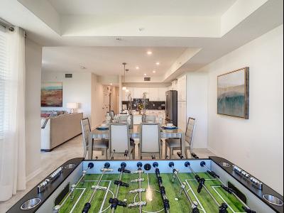 Dining and Gaming Chic: Imbibe in the elegance of our condo's dining area, where sophisticated chairs and a game table set the stage for stylish meals and recreational moments