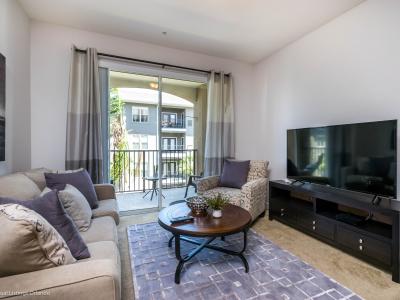 Serene living area of the condo in Orlando Florida - Natural light floods the room, enhancing its warmth and inviting atmosphere - Smart TV for entertainment - Thoughtful mix of textures, from plush rugs to tasteful throw pillows - Cozy Sofas