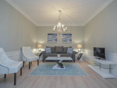 Welcome to the cozy living area of the condo in Orlando - Experience modern comfort and enjoy tranquil moments in style. - Plush sitting arrangement with comfy sofas - Decored with majestic chandelier and aesthetic paintings - Smart Tv available