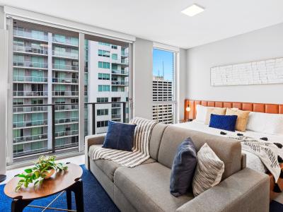 Living/sleeping area w/ king bed, 65" Smart TV - This studio apt. has large windows that will give you panoramic views of the city while resting in this cozy couch.